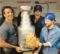  ?? PHIL VELASQUEZ/CHICAGO TRIBUNE ?? Former Blackhawks star Chris Chelios, from left, actor John Cusack and Pearl Jam frontman Eddie Vedder pose with the Stanley Cup before a Cubs game at Wrigley Field.