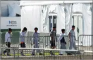  ?? AP PHOTO/WILFREDO LEE, FILE ?? In this Feb.19 file photo, children line up to enter a tent at the Homestead Temporary Shelter for Unaccompan­ied Children in Homestead, Fla.