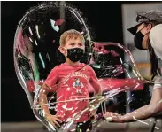  ?? PHOTOS BY JIM WEBER/THE NEW MEXICAN ?? ABOVE: ‘Circus Man’ Jason D’Vaude performs Thursday for a small crowd at the New Mexico State Fair in Albuquerqu­e. RIGHT: Wes Lebron, 5, is encased in a shimmering bubble for a few moments Thursday while playing with his mom, Elizabeth Lebron, at the state fair. FAR RIGHT: California sea lion Poonki performs Thursday at the New Mexico State Fair. The fair ends this weekend.