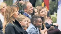  ??  ?? MOM TO MOM: First Lady Melania Trump sits with Judge Amy Coney Barrett’s husband, Jesse Barrett, and their seven kids during Saturday’s nomination announceme­nt in the White House Rose Garden.