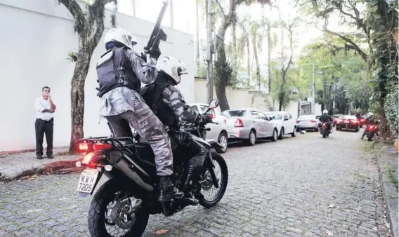  ??  ?? ► Un policía toma posición para escoltar a Bolsonaro tras participar en un programa de televisión en Río de Janeiro.