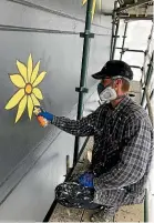  ??  ?? Artist Danny (Deow) Owens works on a new artwork on the south wall of the Kelvin Hotel.