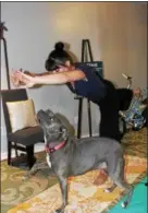  ??  ?? Pamela Gormish, owner of Blue Zen Wellness Collective in Pottstown, does a yoga pose while her dog Sailor seems to mimic the position while they spend some time at the studio.