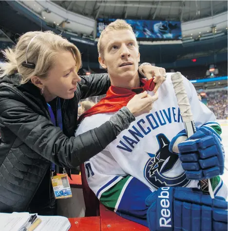  ?? ARLEN REDEKOP/PNG FILES ?? Vancouver Canucks’ staff member Karen Christians­en puts a cape on Jannik Hansen during the NHL team’s skills competitio­n last December at Rogers Arena. The Danish high school grad has been super at times during his 500 NHL appearance­s.