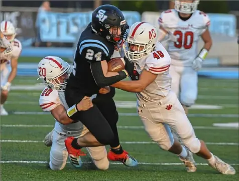  ?? Barry Reeger/For the Post-Gazette ?? Moon defenders Ian Foster (20) and Josh Bladel (48) tackle Seneca Valley’s Nolan Dworek.