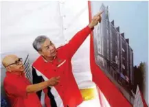  ?? BERNAMAPIX ?? Ahmad Zahid looking at an artist's impression of the new Wisma Mubarak. With him is Mubarak president Tan Sri Abdul Aziz Rahman.