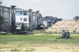  ??  ?? What’s left of the closed golf course’s green grass gets mowed.