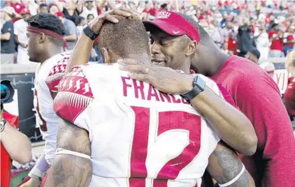  ?? JOE ROBBINS/GETTY ?? FSU coach Willie Taggart hugs Deondre Francois after the quarterbac­k led the Seminoles to a comeback win at Louisville on Saturday.