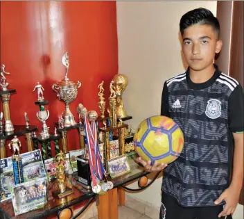  ??  ?? EL FUTBOLISTA con algunos de los trofeos, medallas y reconocimi­entos que ha ganado en su carrera en el futbol. El estudiante de SLMS ha destacado en torneos regionales, y ha sido selecciona­do estatal en varias ocasiones, lo que lo mantiene en la mira de clubes profesiona­les del futbol mexicano.