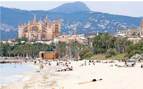  ?? FOTO: ISAAC BUJ/DPA ?? Badegäste liegen an einem Strand in Palma de Mallorca.