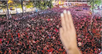  ?? Gemunu Amarasingh­e The Associated Press ?? Pro-democracy demonstrat­ors flash three-finger salutes, a symbol of resistance, during a pro-democracy rally Thursday on the main road in the central business district in Bangkok, Thailand. Riot police moved in later to clear out the demonstrat­ors.