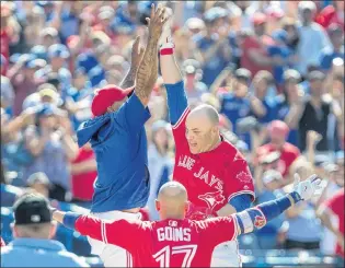  ?? CP PHOTO ?? Toronto Blue Jays’ Steve Pearce high fives with teammate Marcus Stroman after hitting a walk off grand slam to defeat the Los Angeles Angels in their game in Toronto on Sunday.