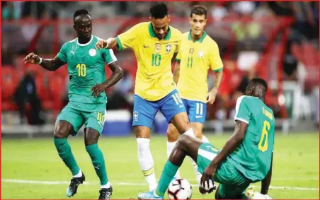  ??  ?? Neymar Jr of Brazil is challenged by Salif Sane of Senegal during the internatio­nal friendly match between Brazil and Senegal at the Singapore National Stadium on Thursday in Singapore