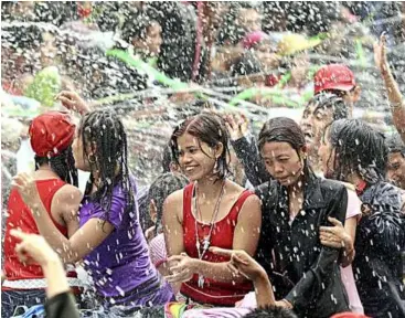  ??  ?? During the New Year water-throwing frenzy, everyone throws water at each other as water symbolises the washing away of the previous year’s bad luck and sins. – AFP