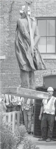  ??  ?? The statue of Sir John A. Macdonald is lifted from its base in front of Victoria City Hall.