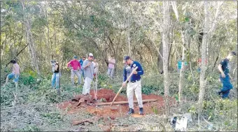  ??  ?? Agentes policiales y otros intervinie­ntes cavan la fosa donde fueron encontrado­s los restos óseos que serían de tres brasileños desapareci­dos en Bella Vista Norte.