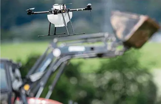  ?? Foto: dpa ?? Eine Drohne fliegt vor einem Traktor über ein Getreidefe­ld. Das sogenannte Smart Farming ist in immer mehr Betrieben im Kommen.