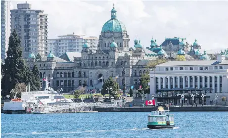  ??  ?? A Victoria Harbour Ferry passes the V2V Empress in front of the Steamship Building and the B.C. legislatur­e.