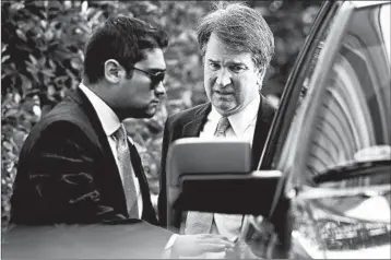  ?? WIN MCNAMEE/GETTY ?? High court nominee Brett Kavanaugh, right, leaves home Wednesday in Chevy Chase, Md. He has denied the allegation.