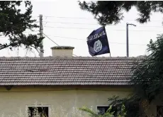  ?? (Murad Sezer/Reuters) ?? AN ISIS FLAG flies over the customs office at Syria’s Jarablus crossing point along the Turkish border on August 1.
