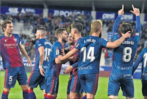  ??  ?? Eugeni Valderrama celebra el gol que abrió la victoria del Huesca, tras recibir la felicitaci­ón de sus compañeros.