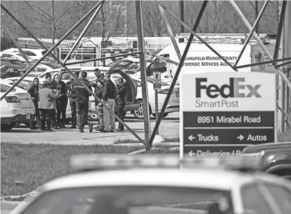  ?? JON CHERRY/GETTY IMAGES ?? Investigat­ors gather in the parking lot of a FedEx facility in Indianapol­is on Friday. Late Thursday night, a gunman killed eight people on the grounds.