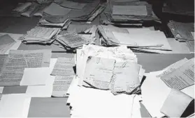  ??  ?? Torn-up documents that the East German secret police hoped to destroy in 1989 and 1990 are reconstruc­ted by “puzzlers.” Some 500 sacks of papers have already been pieced together.