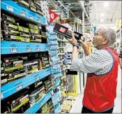  ?? STEVEN SENNE/AP ?? Sales associate Larry Wardford, left, stocks shelves at a Lowe’s in Framingham, Mass. Home improvemen­t chains hired more than 10,000 workers in the month of February.