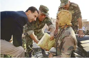  ?? AP ?? Syrian President Bashar Assad speaks with Syrian troops during his visit to the strategic town of Habeet, in the northweste­rn province of Idlib on Tuesday, in this photo released on the official Facebook page of his office.