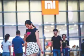  ?? SHEN YANG / FOR CHINA DAILY ?? People shop at a Xiaomizhij­ia, Xiaomi’s direct customer service center, in Shenyang, Liaoning province, on Tuesday.