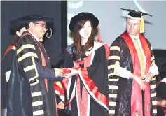  ??  ?? Abang Johari (left) presents a graduate with her scroll.