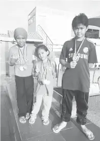  ??  ?? ATIQATUL, Azimatul dan Awangku Hanif bergambar kenangan selepas menerima pingat di kolam renang LIS.