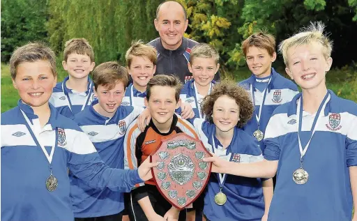  ??  ?? ●● King’s Infant and Junior Division football team with the Macclesfie­ld Primary Schools under 11s trophy