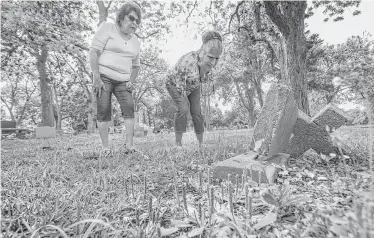  ?? Steve Gonzales photos / Houston Chronicle ?? Terri Rodriguez, left, and Carmen Flores Perez, San Isidro Cemetery associatio­n members, are connected through shared histories of family members working at the sugar mill and then being buried at the cemetery.