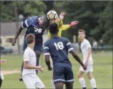  ??  ?? Nottingham’s Franklin Hytegha (26) tries to head the ball as Ewing goalkeeper Kyle Marks punches it away during Monday afternoon’s game. (John Blaine/ For The Trentonian)