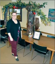  ?? TAMMY KEITH/THREE RIVERS EDITION ?? Melissa Allen of Conway, programs director for the Community Action Program for Central Arkansas, stands in front of The Giving Tree, which she made as part of the Deck the Box contest to collect food for pantries in Faulkner, Cleburne and White counties. Allen isn’t entering the contest, but she wanted to get in on the fun, she said. Votes are being taken on the CAPCA Facebook page, and each county will have a winner for best box, and one overall winner will be named, as well as a winner for the most food collected.