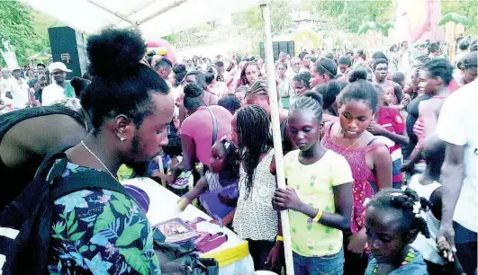  ?? FILE ?? In this 2015 photo, children line up in anticipati­on to receive care packages from entertaine­r Popcaan.