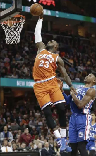  ?? TONY DEJAK — ASSOCIATED PRESS ?? LeBron James, left, dunks against the 76ers’ Richaun Holmes during the first half March 31. The Cavs won, 122‑105.