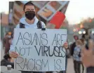  ?? DAMIAN DOVARGANES/AP ?? A demonstrat­or participat­es at a rally “Love Our Communitie­s: Build Collective Power” to raise awareness of anti-Asian violence outside the Japanese American National Museum in Little Tokyo in Los Angeles on March 13, 2021.