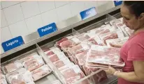  ?? AFP ?? A woman checks beef packing at a supermarke­t in Rio de Janeiro, Brazil. —