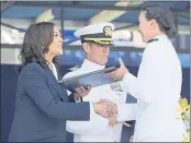  ??  ?? A U.S. Naval Academy graduate receives her diploma from Vice President Kamala Harris at the U.S. Naval Academy in Annapolis, Md., on Friday.