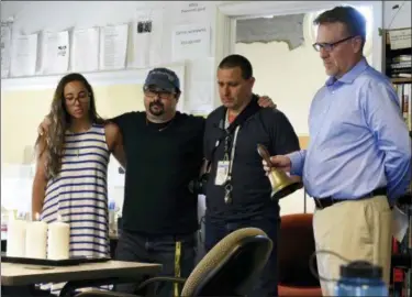  ?? BRIAN KRISTA — THE BALTIMORE SUN VIA AP ?? Rick Hutzell, right, the editor for Capital Gazette, is joined by staff members, from left, reporter Selene San Felice, and photojourn­alists Paul W. Gillespie and Joshua McKerrow, as he rings a bell during a moment of silence at 2:33 p.m., Thursday in Annapolis, Md., for their five colleagues who were killed a week ago in one of the deadliest attacks on journalist­s in U.S. history.