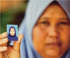  ?? SAWAL PIC BY MUHD ASYRAF ?? Zaleha Abdullah showing a picture of her daughter, Siti Masyitah Ibrahim, at her home in Pekan yesterday.