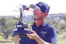  ?? MICHAEL THOMAS/ASSOCIATED PRESS ?? Andrew Landry kisses the trophy for the Valero Texas Open on Sunday in San Antonio. Landry, who lives in Austin, won with a score of 17-under par to earn $1,116,000 and a spot in the Masters.