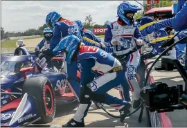  ?? CHIP GANASSI RACING VIA AP ?? Danielle Shepherd, at right with the clear sheet in her hand, works in the pit for auto racing driver Alex Palou during the Honda Indy Grand Prix of Alabama auto race at Barber Motorsport­s Park, on April 18in Birmingham, Ala.