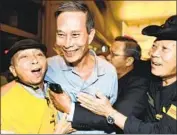  ?? Robyn Beck AFP/Getty Images ?? FREED Vietnamese dissident Nguyen Van Hai, center, was greeted upon his arrival at LAX in 2014.
