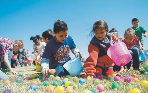  ?? Brent Lewis, Denver Post file ?? Children rush to grab eggs off the ground during an Easter egg hunt at The Potter’s House of Denver. The church released 25,000 eggs.