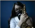  ?? GINNETTE RIQUELME — THE ASSOCIATED PRESS ?? Maria Elena R'os holds her saxophone at the end of a rehearsal at the National Autonomous University of Mexico music department in Mexico City on Tuesday.