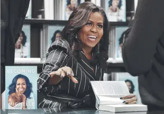  ??  ?? Former First Lady Michelle Obama signs books during an appearance for her memoir, Becoming, in New York.