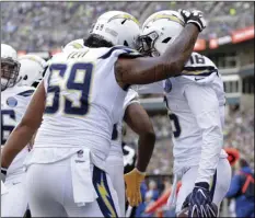  ?? AP PHOTO/TED S. WARREN ?? Los Angeles Chargers’ Tyrell Williams (right) is congratula­ted by Sam Tevi on his touchdown against the Seattle Seahawks during the first half of an NFL football game, Nov. 4, in Seattle.